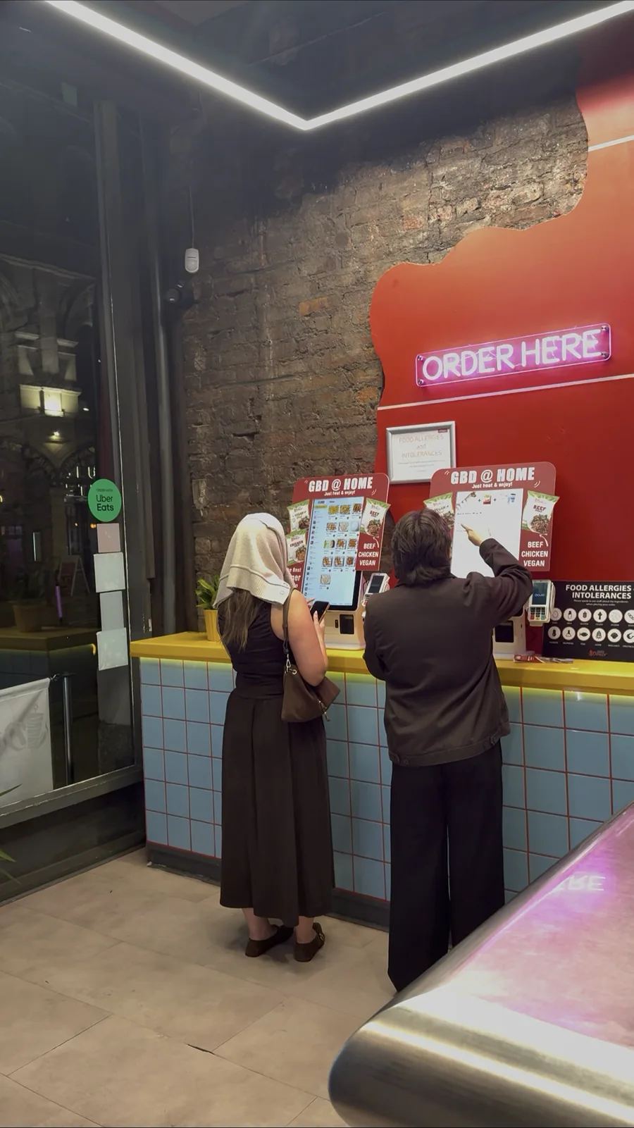 Two guests ordering at ZanPOS counter kiosks at Great British Doner