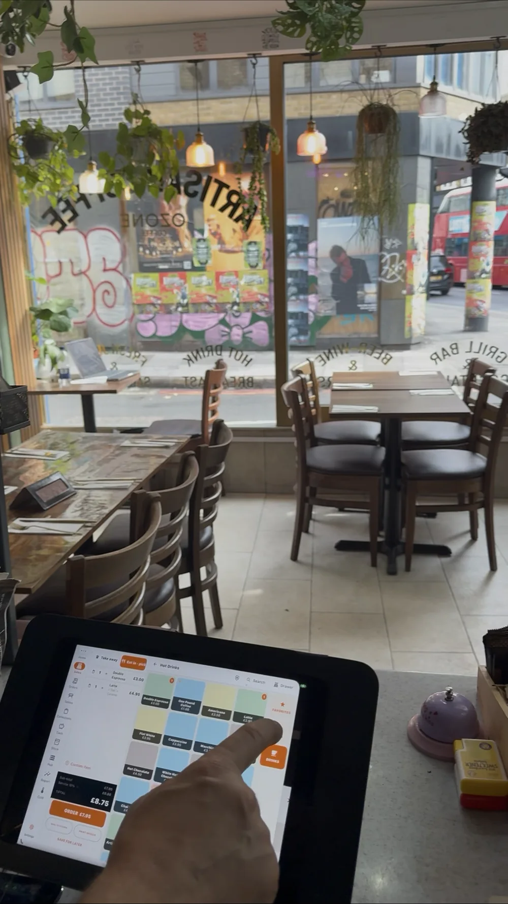 ZanPOS till in use at Artist Cafe, London — a hand tapping a latte on the iPad till